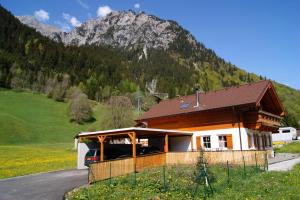 a building with a mountain in the background at Haus Servus in Klösterle am Arlberg