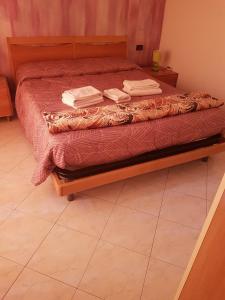 uma cama com uma estrutura de madeira com duas toalhas em Bergamo City Apartments em Bérgamo