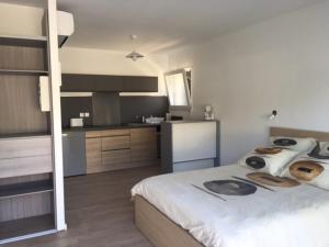 a bedroom with a large bed and a kitchen at Appartements Les Pesquiers Hyères Plage in Hyères