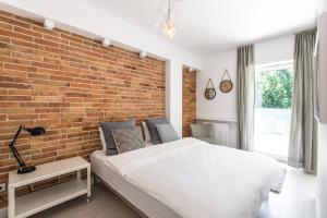 una camera da letto con un muro di mattoni e un letto di Super-Apartamenty Exotic a Poznań