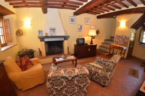 a living room with chairs and a fireplace at Batticapo di Ilaria in San Martino in Freddana