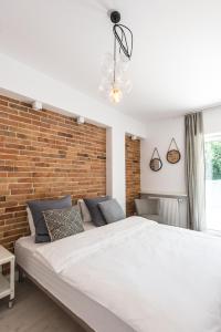 una camera con un grande letto e un muro di mattoni di Super-Apartamenty Exotic a Poznań