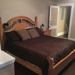 a bedroom with a large bed with a wooden headboard at Magnificent Place-Moreland in Atlanta