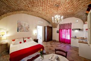 a bedroom with a bed and a table and a kitchen at Residence La Pera Bugiarda in Venaria Reale