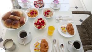 una mesa con platos de desayuno y tazas de café en Villa Bella, en Ohrid