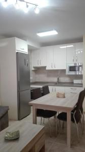 uma cozinha com uma mesa e um frigorífico de aço inoxidável em Apartamento Las Tortugas em Arroyo Frío