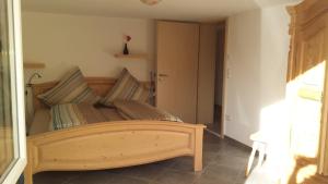 1 dormitorio con cama de madera y almohadas a rayas en Ferienwohnung Valentin, en Hohenpeißenberg