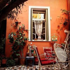 a red wall with a window and chairs in front at Athens Quinta in Athens