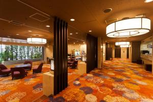 a lobby of a hotel with chairs and tables and a room at Morioka Grand Hotel Annex in Morioka