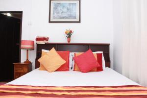 米瑞莎的住宿－米麗薩朱美拉別墅，一间卧室配有带色彩缤纷枕头的床