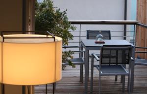 balcón con mesa, sillas y lámpara en Weingut Gästehaus Weigand, en Iphofen