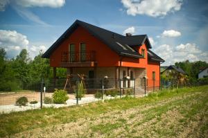 uma casa com uma cerca em frente em Agroturystyka Katarzyna em Święta Katarzyna