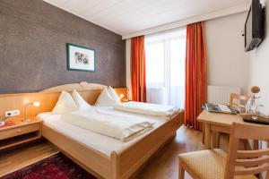 A bed or beds in a room at Noichl’s Hotel Garni
