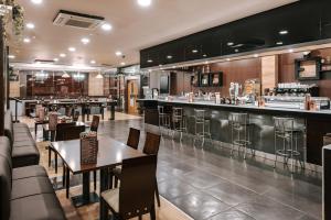 a restaurant with tables and chairs and a bar at Zenit Aparthotel Hall 88 in Salamanca