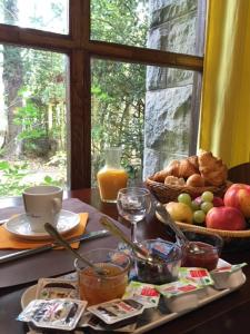 a table with a tray of food and a basket of fruit at Hôtel Restaurant les Platanes in Montfaucon-en-Velay