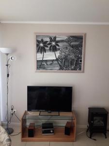a living room with a flat screen tv on a table at Laguna Vista in Algarrobo