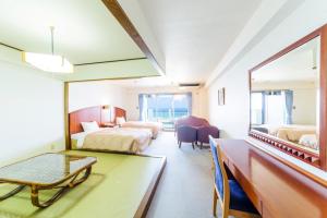 a hotel room with two beds and a table at Kanehide Onna Marine View Palace in Onna