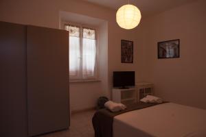 sypialnia z łóżkiem, telewizorem i lampką w obiekcie Residenza Cleopatra 1 w mieście Ancona
