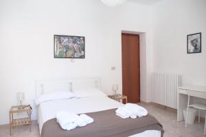 biała sypialnia z łóżkiem i ręcznikami w obiekcie Residenza Cleopatra 1 w mieście Ancona