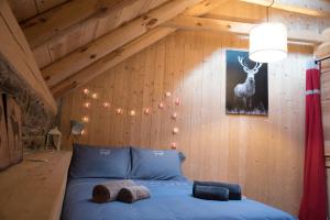 ein Schlafzimmer mit einem blauen Bett mit einem Hirsch an der Wand in der Unterkunft Le Castanier in Montauban-de-Luchon