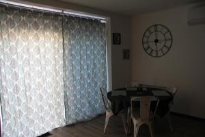 a dining room with a table and a clock on the wall at Studio 5 # Tom in Pierrelatte