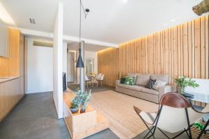 uma sala de estar com um sofá e uma mesa em Wood Wall & Garden Apartment em Lisboa