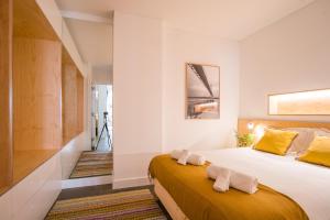 1 dormitorio con 1 cama grande y toallas. en Wood Wall & Garden Apartment, en Lisboa