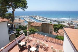 a balcony with tables and chairs and a view of a marina at Albergo La Pineta in Marina di Andora