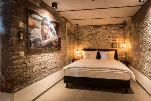 a bedroom with a bed in a brick wall at Kochs Stadthotel in Olpe