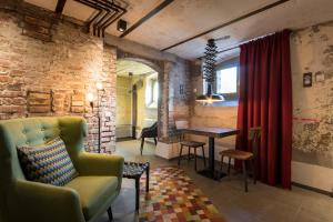 Kochs Stadthotel في أولبه: غرفة معيشة مع كرسي أخضر وطاولة