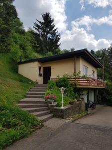 una casa con una escalera delante de ella en Ferienhaus Chalet Cottage Ourtalblick 2km von Vianden-Lux, en Roth