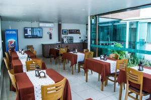 a restaurant with tables and chairs in a room at Dalle Hotel in Bagé