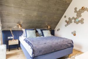 um quarto com uma cama azul e uma parede de madeira em Apartamenty Pod Giewontem em Zakopane