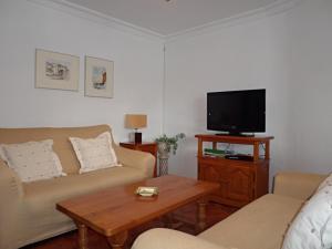 sala de estar con sofá y TV en PALMERAS 9 MENYBER, en Nerja