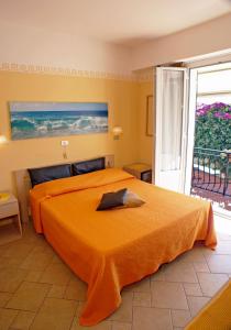 a hotel room with a bed, table and window at Albergo La Pineta in Marina di Andora