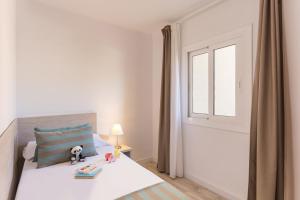 Un dormitorio con una cama y una ventana con un animal de peluche. en Pierre & Vacances Estartit Playa en L'Estartit