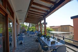 a patio area with tables, chairs and umbrellas at Albergo La Pineta in Marina di Andora