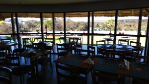 コスタリカにあるIves Hotelのテーブルと椅子、大きな窓のあるレストラン