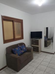 a living room with a couch and a flat screen tv at Apto Jk em Cachoeirinha in Cachoeirinha