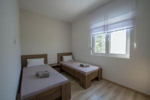 um quarto com duas camas e uma janela em Oasis Flowers Medjugorje em Medjugorje