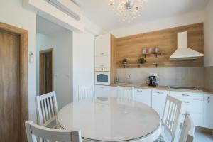 uma cozinha branca com uma mesa e cadeiras brancas em Oasis Flowers Medjugorje em Medjugorje