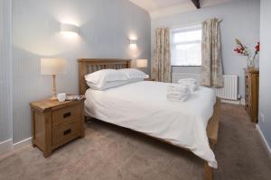 a bedroom with a large white bed and a window at Wagtail Cottage in Berwick-Upon-Tweed