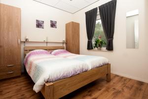 een slaapkamer met een bed en een raam bij Camping en vakantiewoning 'Ut Tumpke' in Kessel