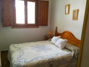 デニアにあるAnacasa Adosado Riu Montan Deveses AD4101のベッドルーム1室(木製ヘッドボードと窓付)