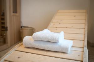 a stack of towels sitting on top of a wooden table at B&B La Vetta -petite SPA- in Potenza