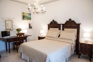 um quarto com uma cama, uma secretária e um lustre em B&B La Vetta -petite SPA- em Potenza
