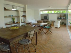 a kitchen and living room with a table and chairs at Casa em condomínio fechado de frente para o mar e ao lado do rio in Praia Guaratuba