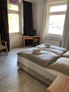1 dormitorio con 1 cama, escritorio y 2 ventanas en Fettehenne Gästehaus en Erkrath
