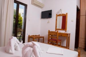 a room with a bed with towels on it at Paradise Matala Hotel in Matala