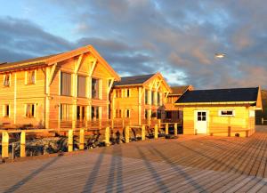 eine Reihe von Holzhäusern auf einem Dock mit einem Flugzeug in der Unterkunft Mikkelvik Brygge in Mikkelvika